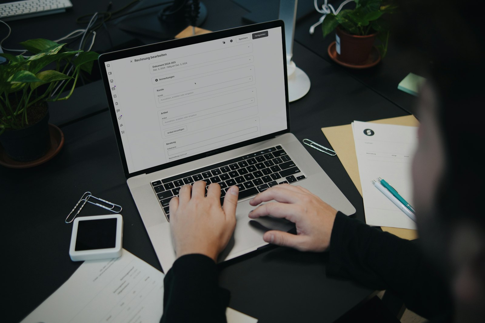 A person sitting at a desk, working through something carefully on a laptop